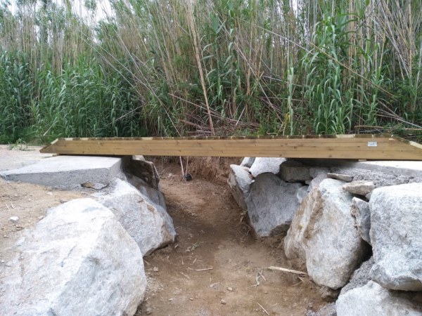 Pasarela de madera tratada en la riera